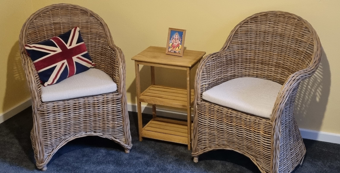 two wicker chairs, there is a union flag pillow on one of them