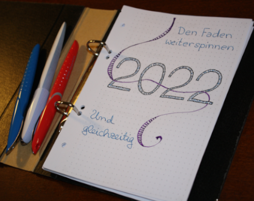 happy new year: photo of a new self made bullet journal. on the first page the number 2022 appears